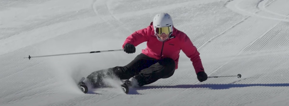 Personne réalisant un virage carvé avec des skis paraboliques